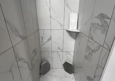 White marble look tile shower with hex mosaic floor at Kentucky Tile Distributors in Owensboro, KY