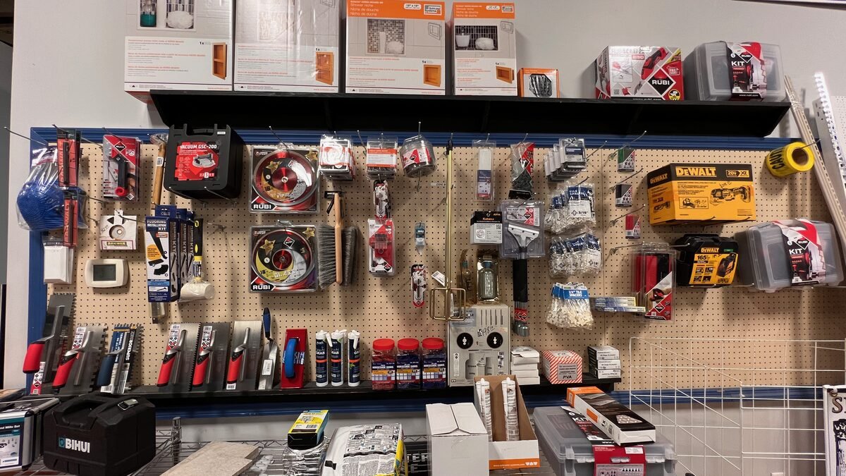 Tile tools wall with trowels, spacers, saw blades, and caulk at Kentucky Tile Distributors in Owensboro, KY